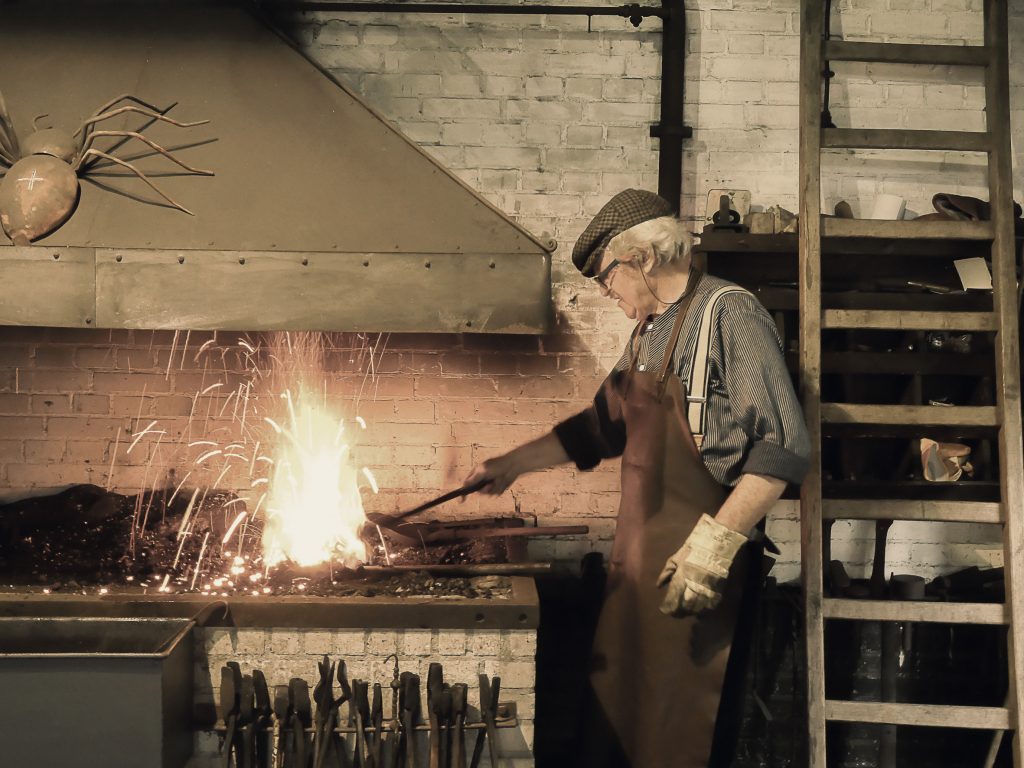 De smid aan het werk in de smederij van het museum